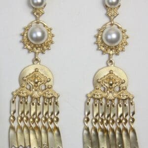 A pair of gold earrings with pearls hanging from them.