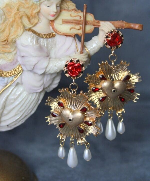 A pair of earrings with gold and red beads.