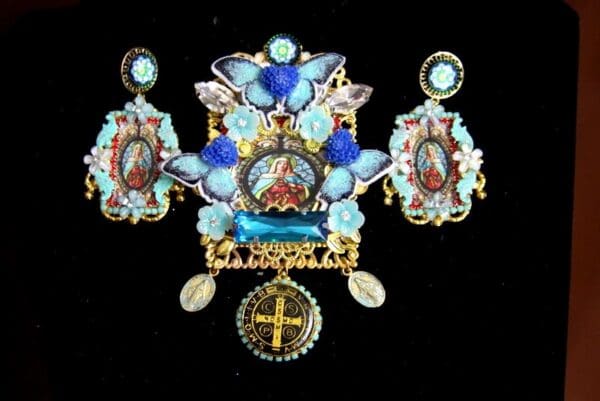 A set of jewelry with blue flowers and religious images.