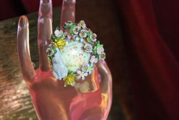 A hand with flowers on it is holding something.