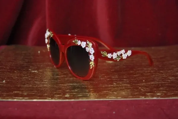 A red pair of sunglasses with flowers on it.