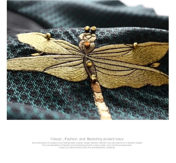 A close up of the golden dragonfly on a green cloth