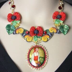 A necklace with flowers and a picture of a woman.