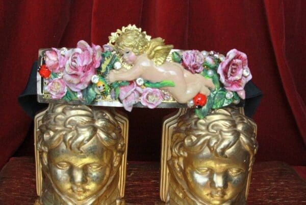 A pair of gold bookends with flowers and cherubs.