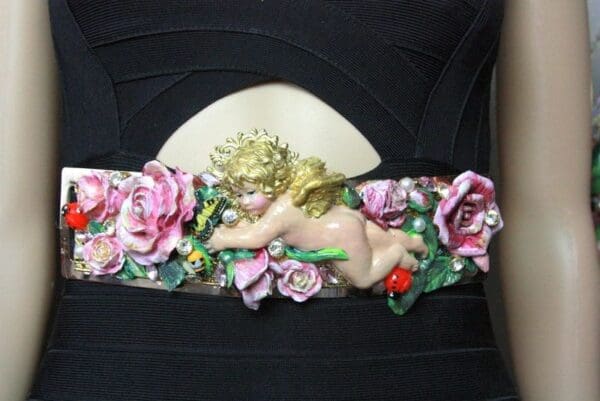 A close up of the belt with flowers and a cherub