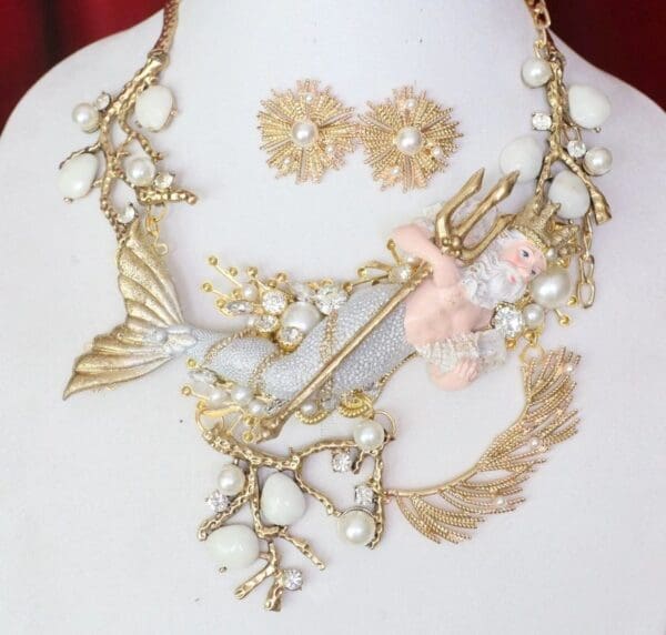 A necklace and earrings set with gold leaves, flowers and pearls.