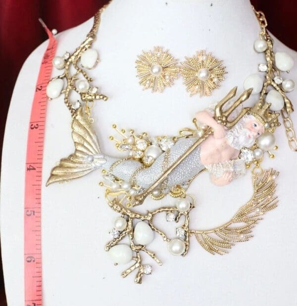 A necklace and earrings set with gold leaves, flowers and pearls.