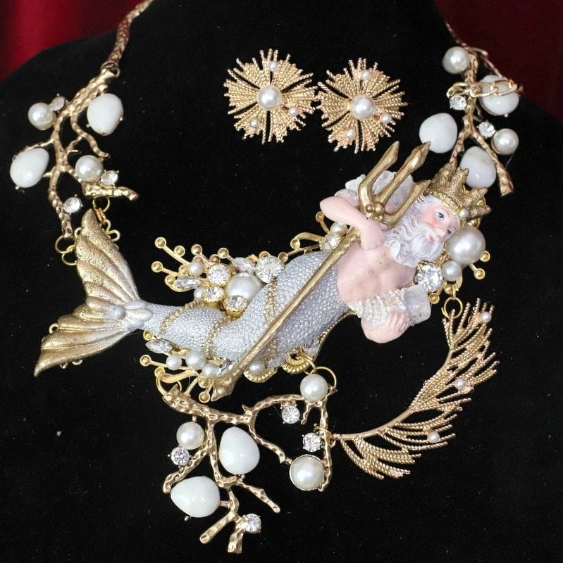 A necklace and earrings set with pearls, shells and gold.