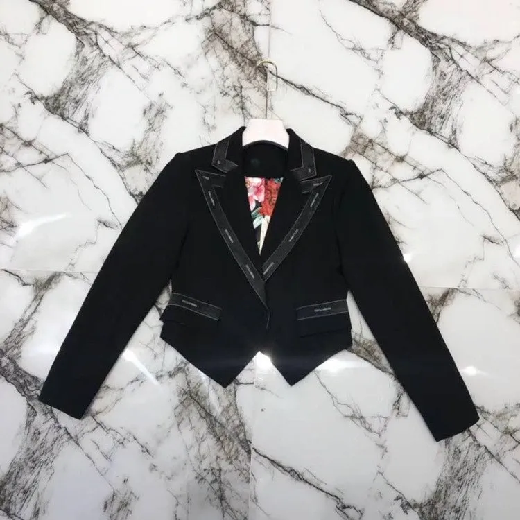 A black jacket with a red tie on top of marble.