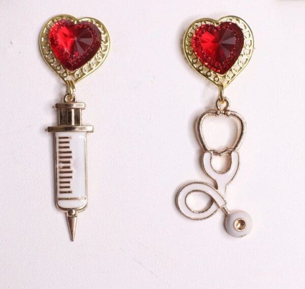 A pair of earrings with a heart and a syringe.