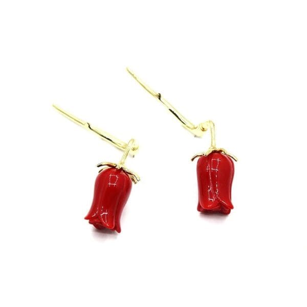 A pair of red peppers hanging from gold wires.