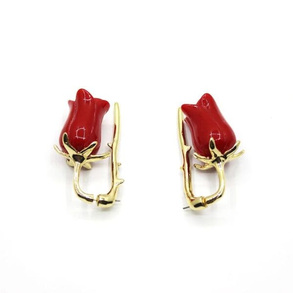 A pair of red and gold earrings.