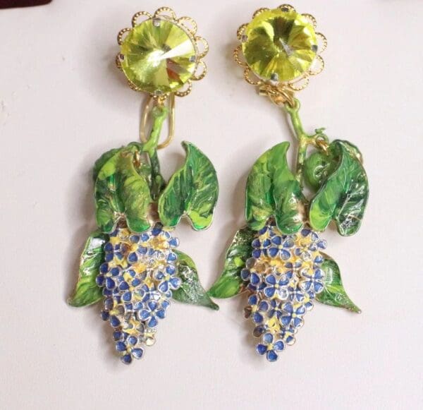 A pair of earrings with grapes and leaves.