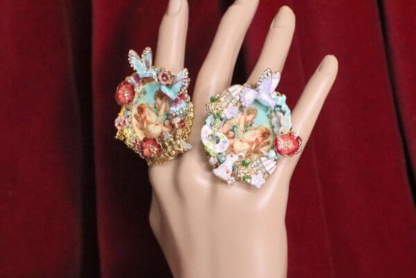 A hand wearing two rings with different designs on them.