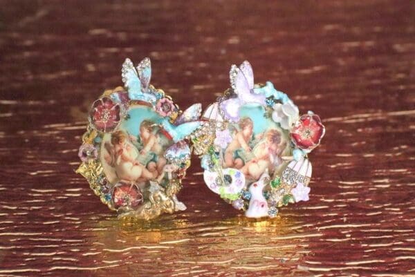 Two figurines of angels with a butterfly on them.