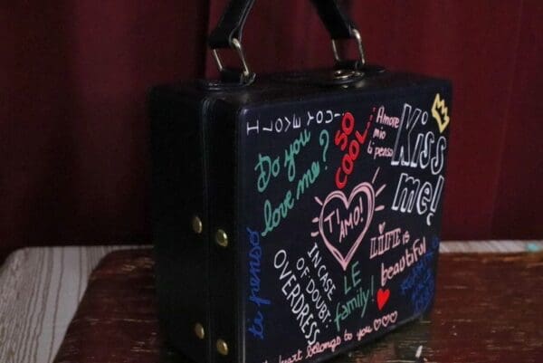 A black bag with many different stickers on it.