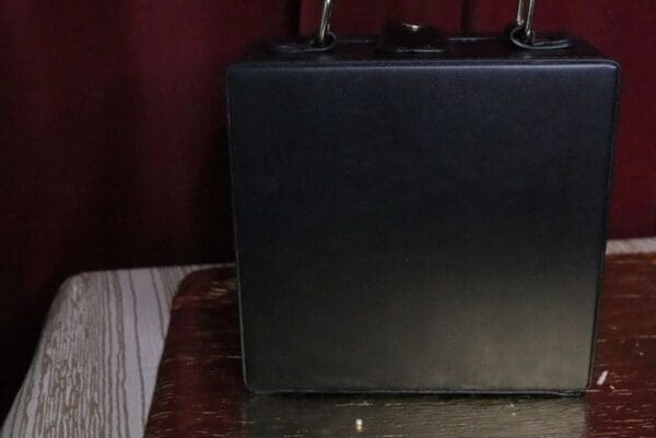 A black suitcase sitting on top of a bed.