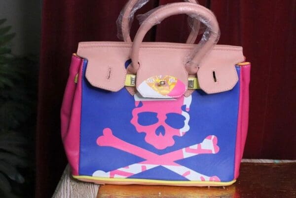 A pink and blue bag with a skull on it