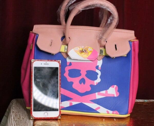 A cell phone and purse sitting on top of a table.