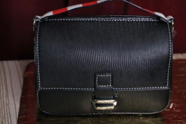 A black purse sitting on top of a table.