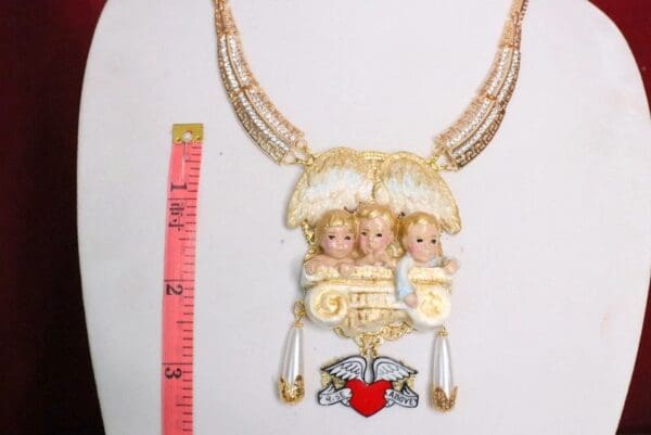 A necklace with three little girls on it