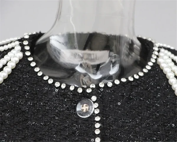 A black sweater with silver and white beads on it.