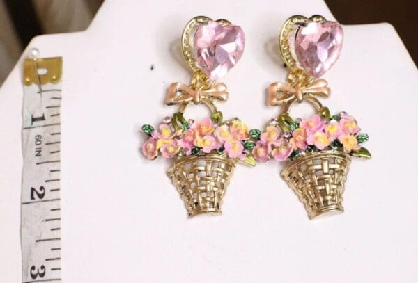 A pair of earrings with flowers and bows on top.