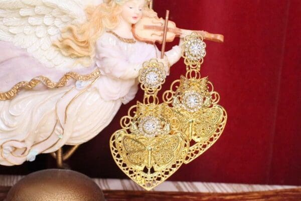 A pair of gold earrings with white stones.