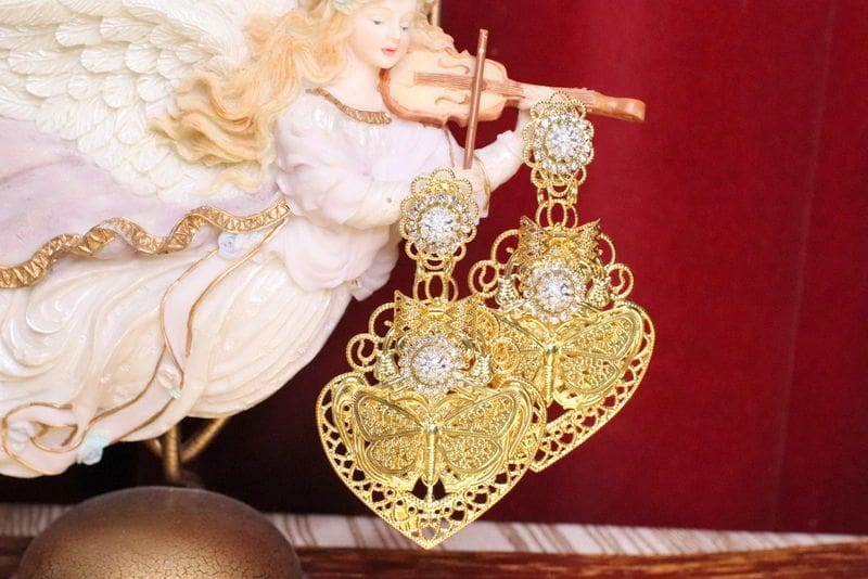 A pair of gold earrings with white stones.