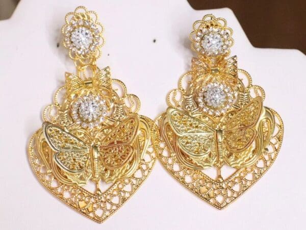 A pair of gold earrings with white stones.