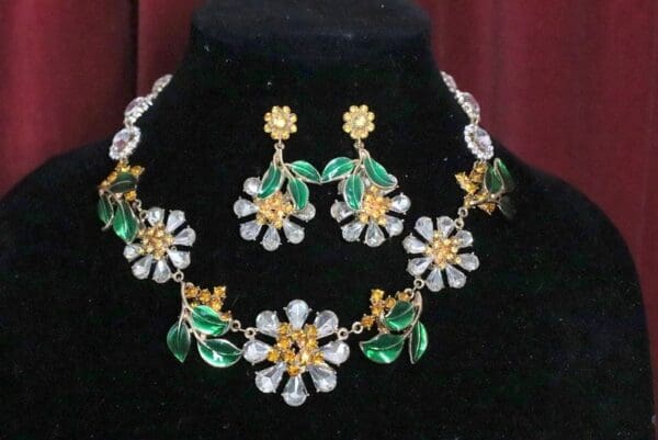 A necklace and earrings set with green leaves.