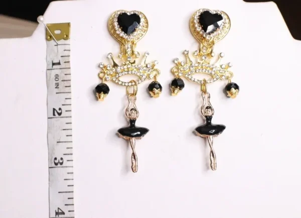 A pair of earrings with black and gold accents.