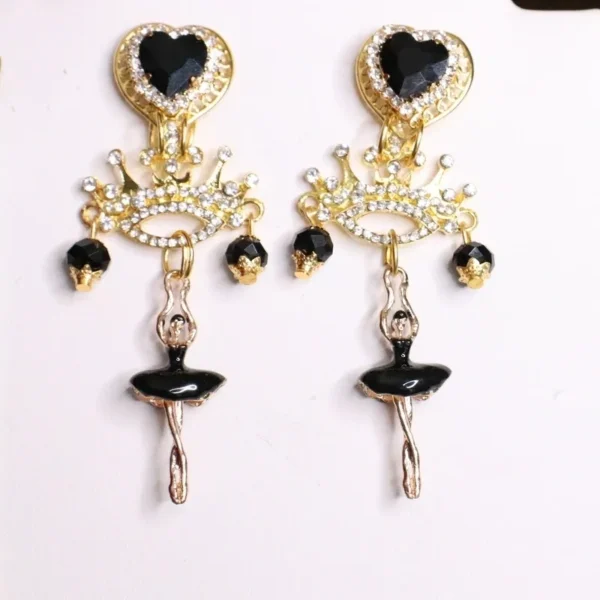 A pair of earrings with black and gold designs.