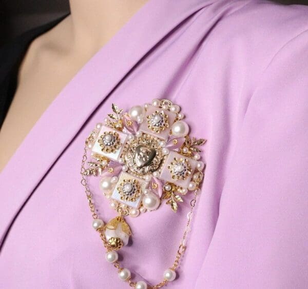 A woman wearing a pink dress and holding onto pearls