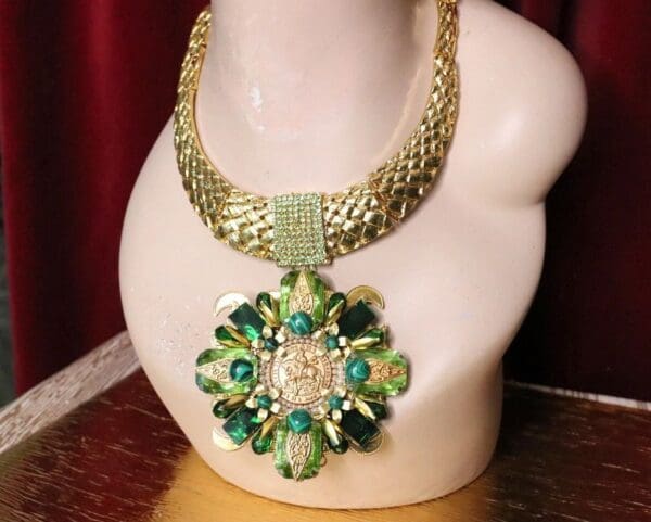 A necklace with green beads and a large pendant.