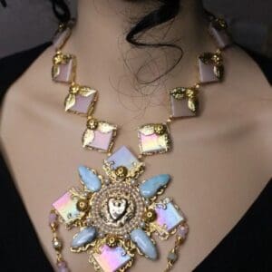 A woman wearing a necklace with a large pendant.
