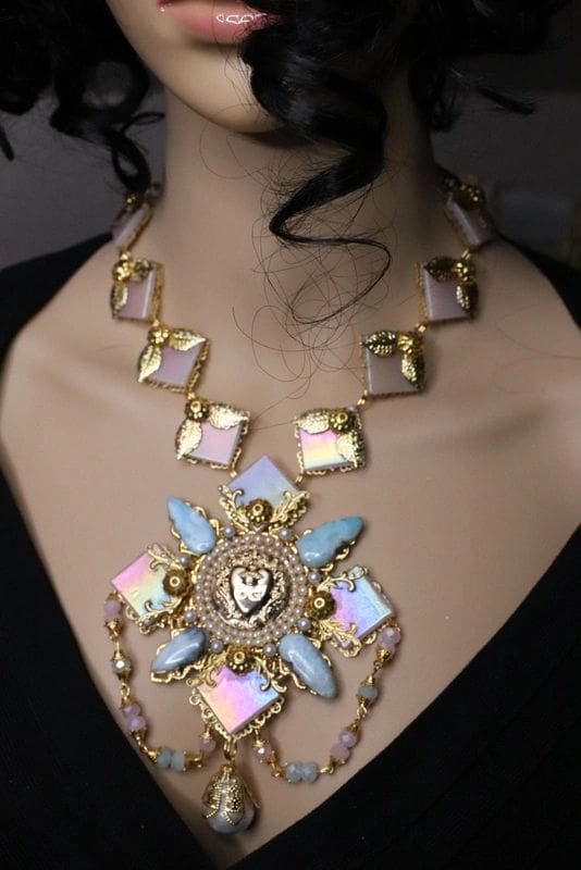 A woman wearing a necklace with a large pendant.