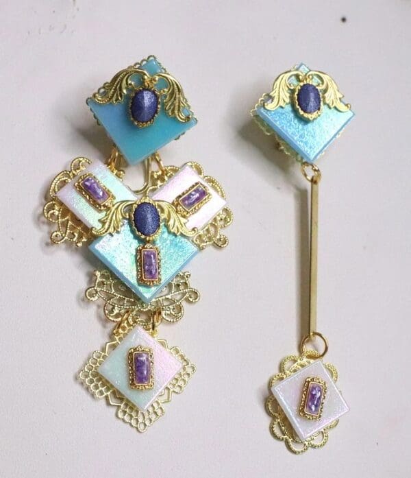 A pair of earrings with blue and white stones.
