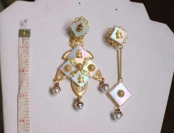A pair of earrings with gold and white enamel.