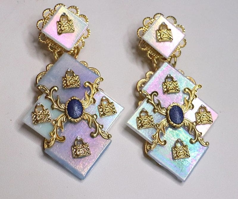 A pair of earrings with gold and blue stones.