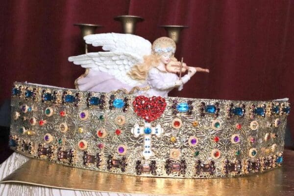 A statue of an angel on top of a crown.