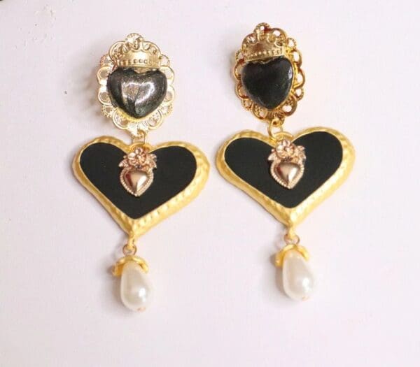 A pair of earrings with black and gold hearts.