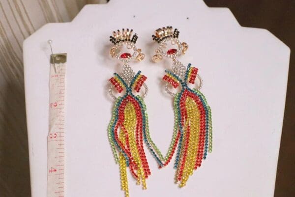 A pair of beaded earrings with a woman 's face.