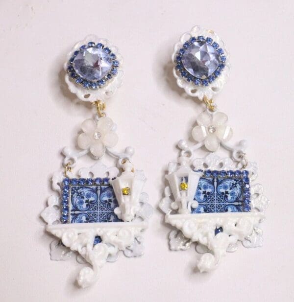 A pair of earrings with blue and white designs.