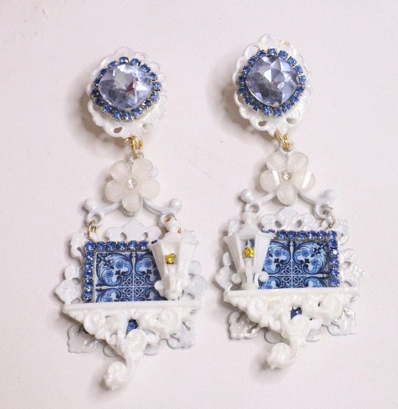 A pair of earrings with blue and white designs.