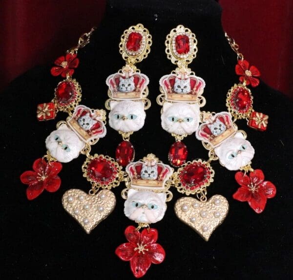 A necklace and earrings set with red flowers.
