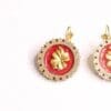 A pair of earrings with red and gold design.
