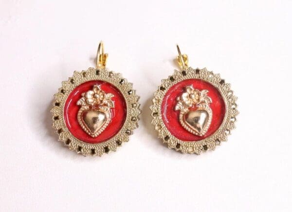 A pair of earrings with red and gold hearts.