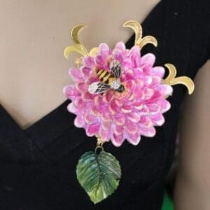 A woman wearing a black dress with pink flower and bee.