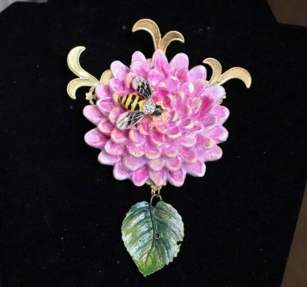 A pink flower with leaves and two bees on it.